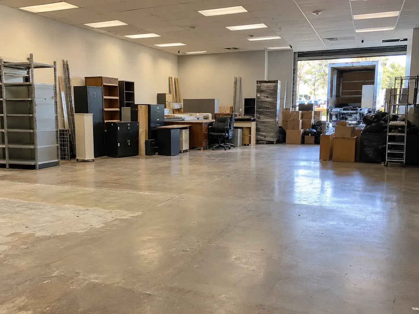 Office furniture and shelving staged during a commercial cleanout